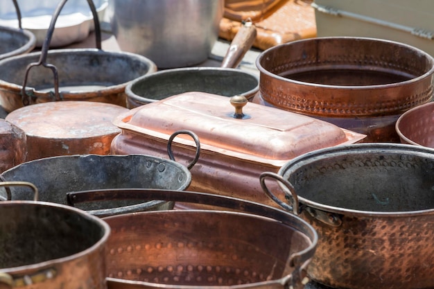 Copper cookware displayed on a wooden workshop surface